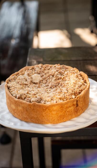 Torta de pera com banana inteira, com farofa dourada por cima, sobre prato branco